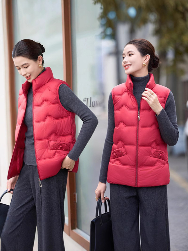 Sieviešu veste ar stāvošu apkakli; tievs piegriezums; īss garums 40–50 cm; rāvējslēdzējs; poliestera audums