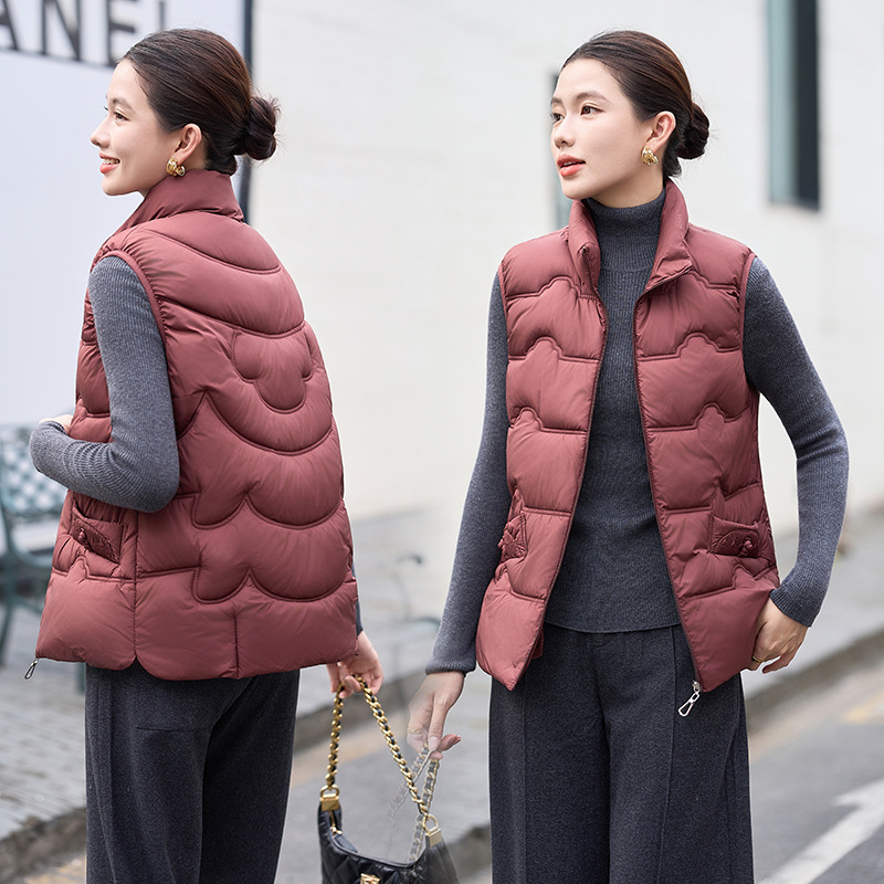 Sieviešu veste ar stāvošu apkakli; tievs piegriezums; īss garums 40–50 cm; rāvējslēdzējs; poliestera audums