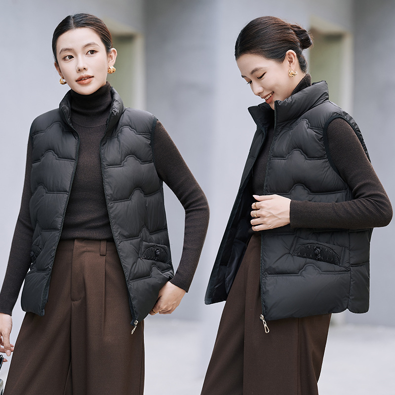 Sieviešu veste ar stāvošu apkakli; tievs piegriezums; īss garums 40–50 cm; rāvējslēdzējs; poliestera audums