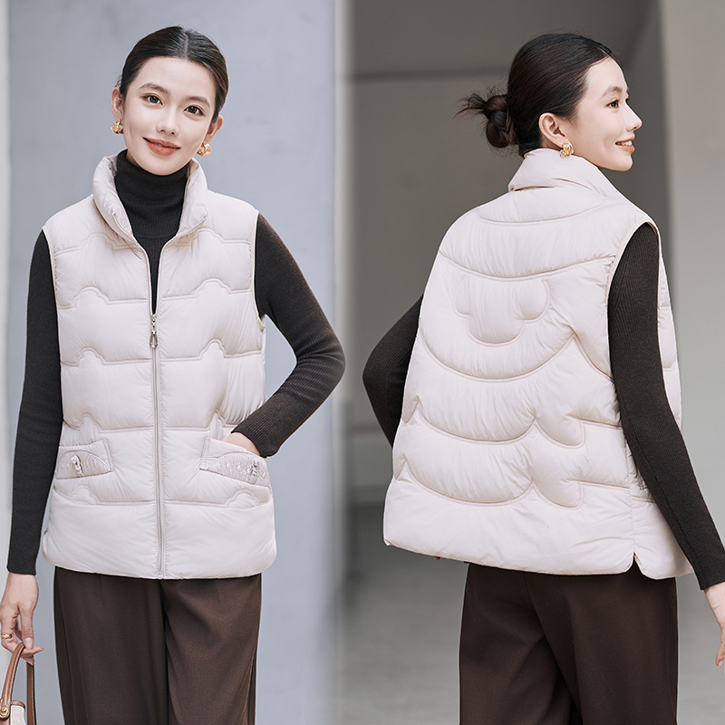 Sieviešu veste ar stāvošu apkakli; tievs piegriezums; īss garums 40–50 cm; rāvējslēdzējs; poliestera audums