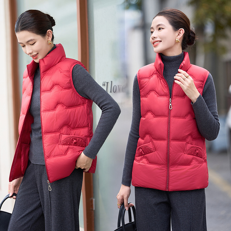 Sieviešu veste ar stāvošu apkakli; tievs piegriezums; īss garums 40–50 cm; rāvējslēdzējs; poliestera audums