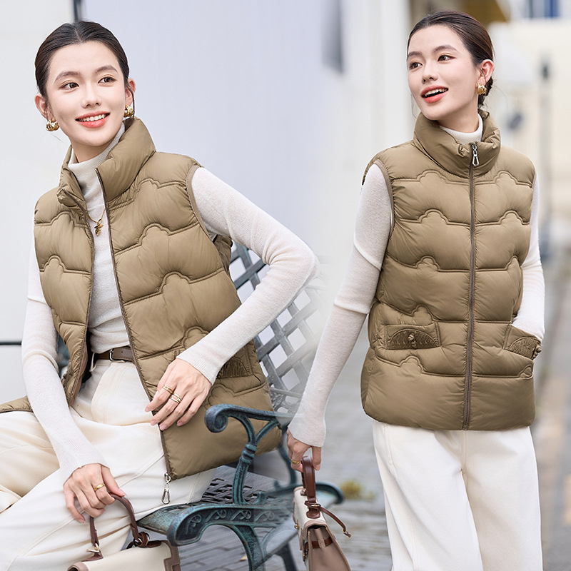 Sieviešu veste ar stāvošu apkakli; tievs piegriezums; īss garums 40–50 cm; rāvējslēdzējs; poliestera audums