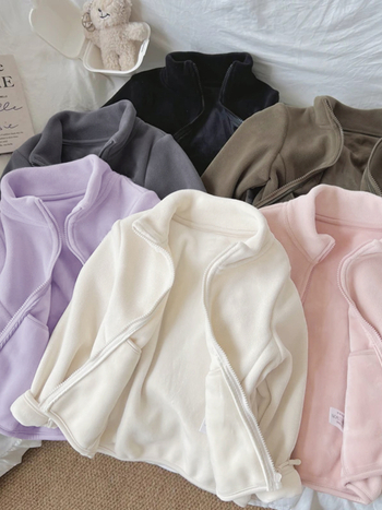 Unisex bērnu flisa jaka ar augstu apkakli, rāvējslēdzējs priekšā, bieza flīze, vienkrāsaina, garas piedurknes, īss garums, pildījums 100% poliesters, pamata audums poliesters, bez kapuces, bērniem 3–8 gadi, ziemas 2025 izlaidums