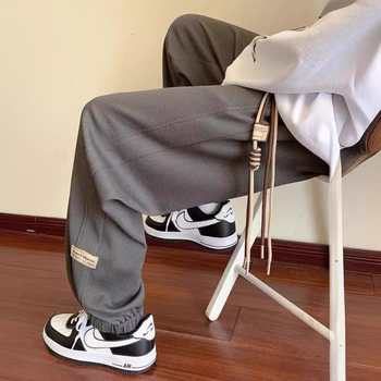 Kényelmes, laza szabású sportnadrág, középmagas derekú, zsinóros zárás, poliészter-keverék anyag és elasztikus.