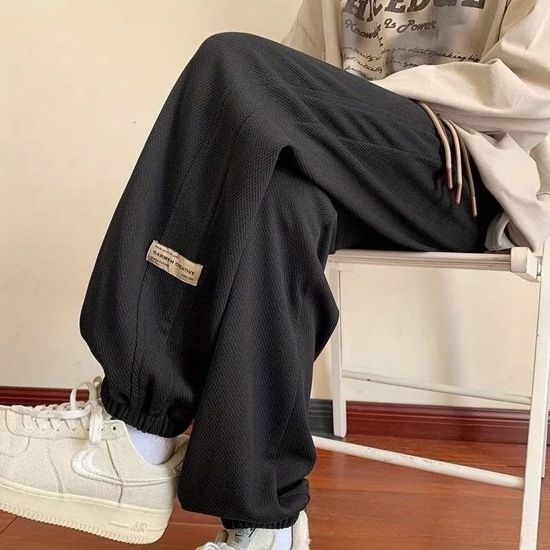 Kényelmes, laza szabású sportnadrág, középmagas derekú, zsinóros zárás, poliészter-keverék anyag és elasztikus.