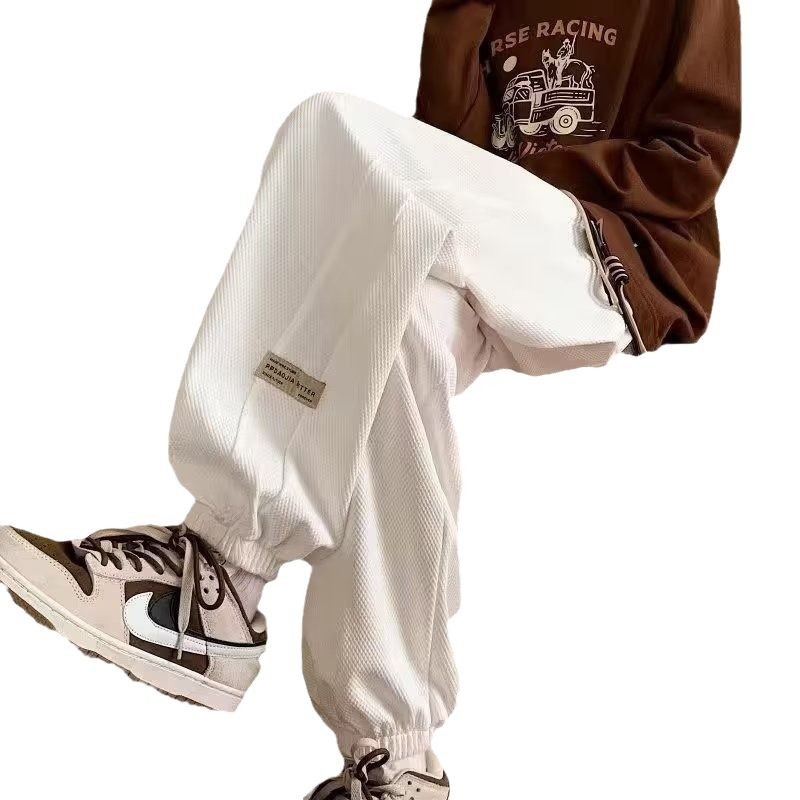 Kényelmes, laza szabású sportnadrág, középmagas derekú, zsinóros zárás, poliészter-keverék anyag és elasztikus.