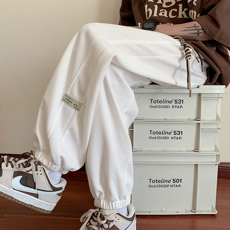 Kényelmes, laza szabású sportnadrág, középmagas derekú, zsinóros zárás, poliészter-keverék anyag és elasztikus.