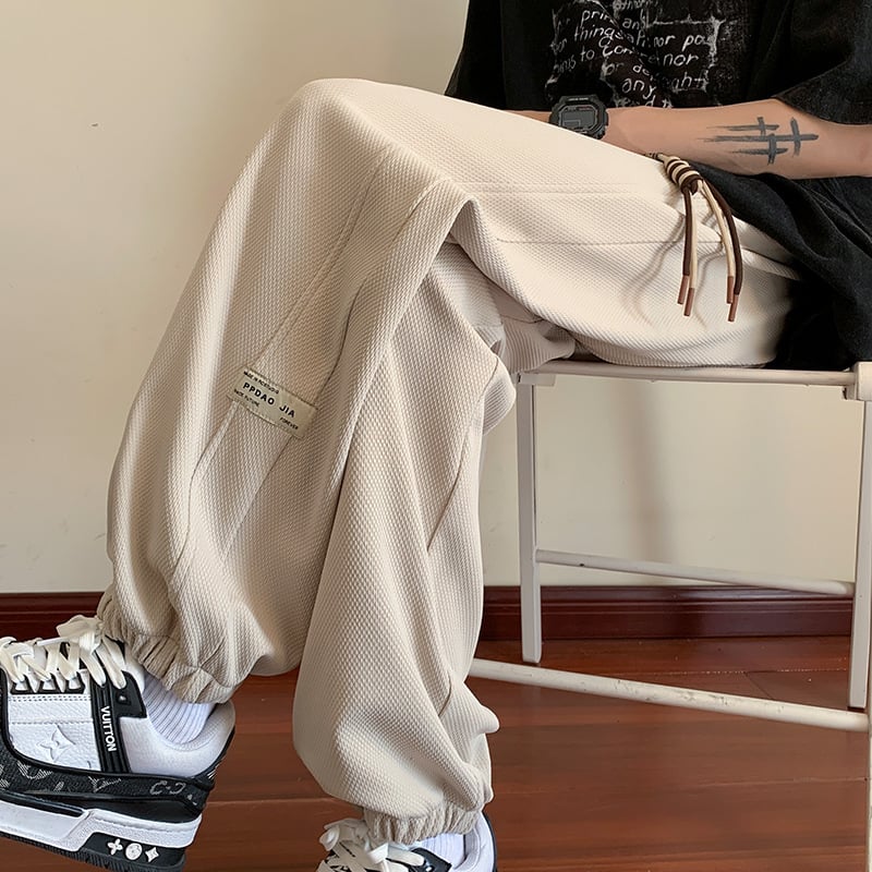 Kényelmes, laza szabású sportnadrág, középmagas derekú, zsinóros zárás, poliészter-keverék anyag és elasztikus.