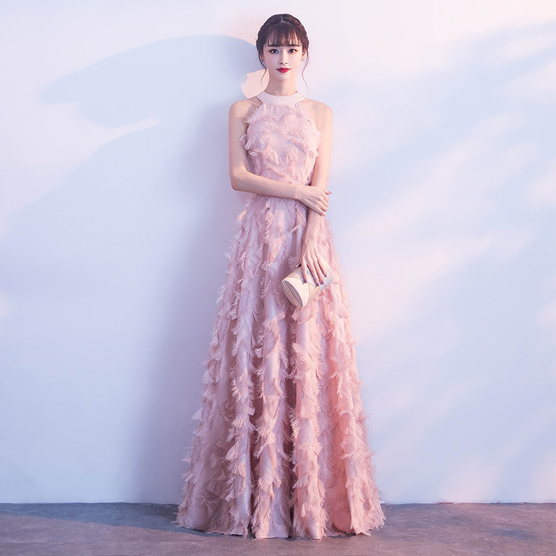 Balta plunksnų apdaila su atvirais pečiais, ilga vakarinė suknelė su aukštu liemeniu, skirta baigimui ir choro pasirodymams