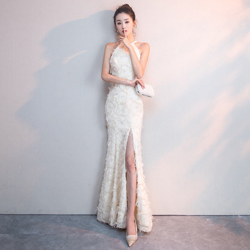 Balta plunksnų apdaila su atvirais pečiais, ilga vakarinė suknelė su aukštu liemeniu, skirta baigimui ir choro pasirodymams