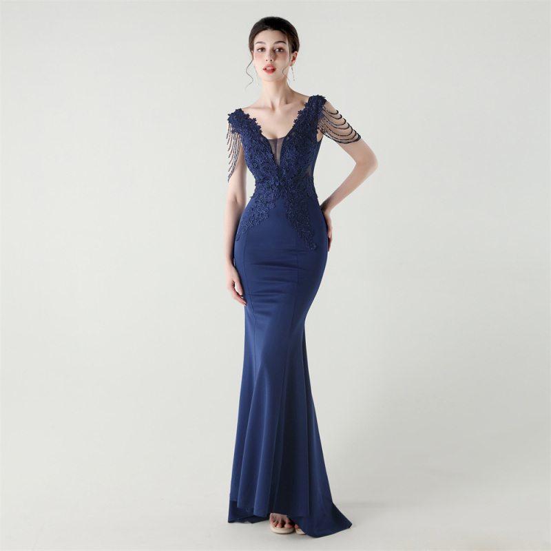 Vakarinė suknelė iš satino su nėrinių ir kristalų akcentais, gili V formos iškirptė, nugaros dirželis, liekninanti liemens siluetas, be rankovių, ilga suknelė