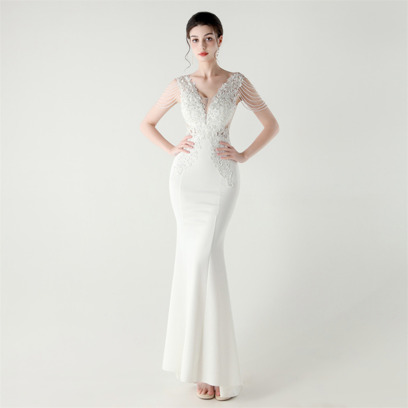 Vakarinė suknelė iš satino su nėrinių ir kristalų akcentais, gili V formos iškirptė, nugaros dirželis, liekninanti liemens siluetas, be rankovių, ilga suknelė