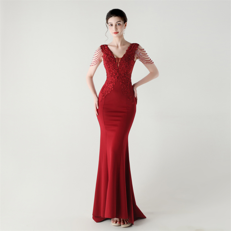 Vakarinė suknelė iš satino su nėrinių ir kristalų akcentais, gili V formos iškirptė, nugaros dirželis, liekninanti liemens siluetas, be rankovių, ilga suknelė