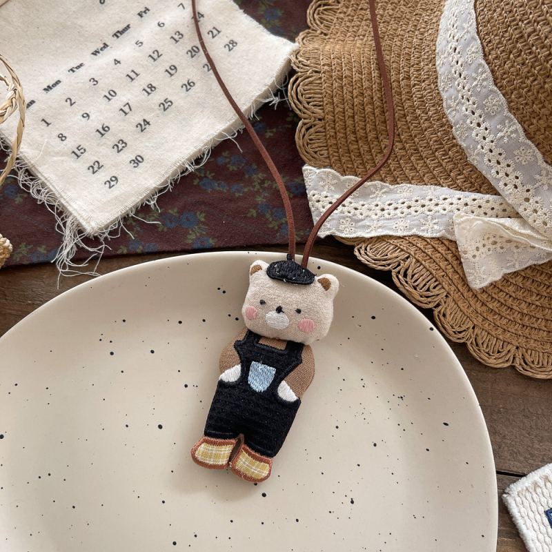 Rokām darināta bērnu kaklarota ar auduma kulonu, karikatūras dzīvnieka tēls, no auduma; piemērota vecumam 3–10+ gadi