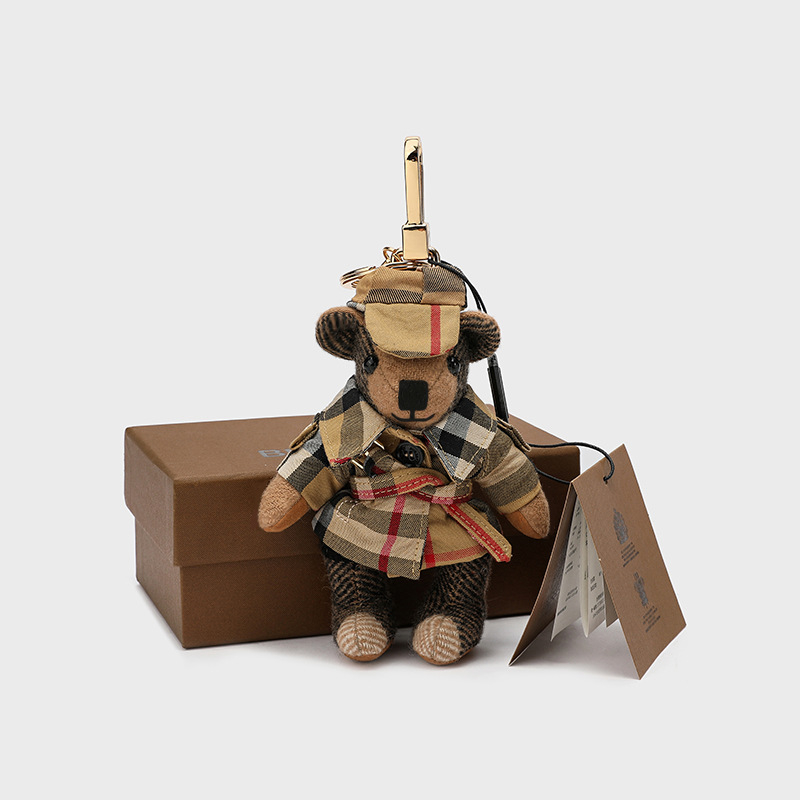 Lācīša formā plīša kulons somām; kašmīra materiāls ar metāla pārklājumu; oriģinālais dizains, piemiņas stilā; uzraksts ar lāci un maziem dzīvniekiem; karu tekstūra