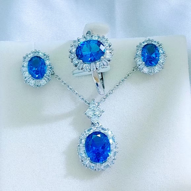 Sieviešu rotu komplekts: kaklarota, auskari un gredzens, metāla pamatne; sudraba pārklājums uz vara ar sintētiskiem akmeņiem; ziedu raksts; O formas ķēde; 2025. gada pavasaris