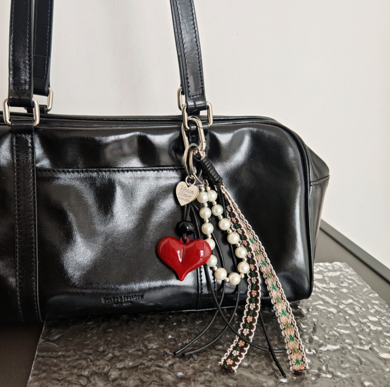 Somai uzkarināms rotājums ar kulonu un atslēgu piekariņu; motīvi: mīlestība, pilieni, zvani; augstākās klases modes aksesuārs, izlaidums rudens 2024