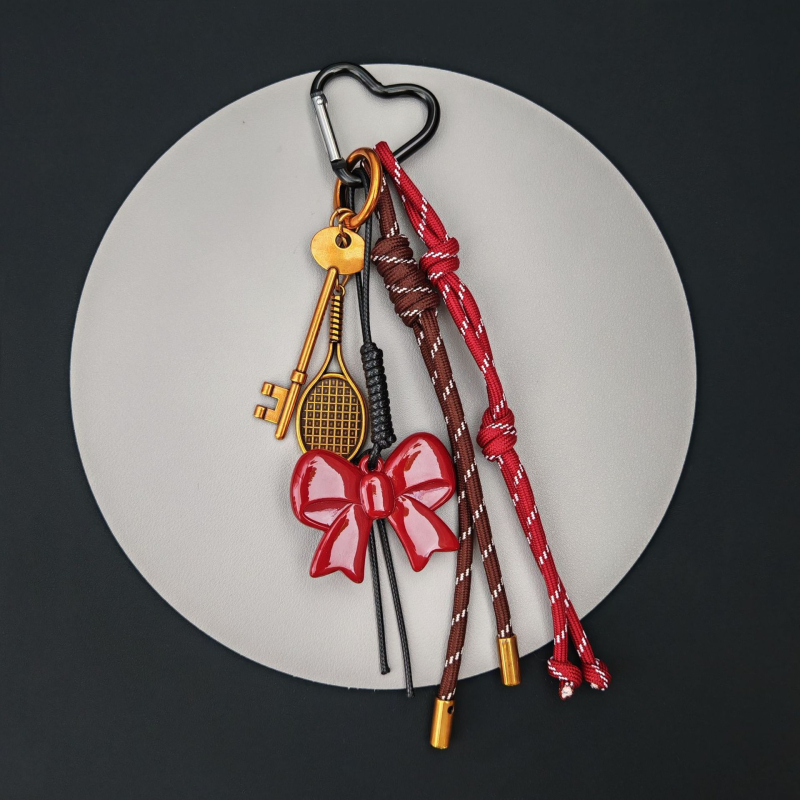 Somai uzkarināms rotājums ar kulonu un atslēgu piekariņu; motīvi: mīlestība, pilieni, zvani; augstākās klases modes aksesuārs, izlaidums rudens 2024