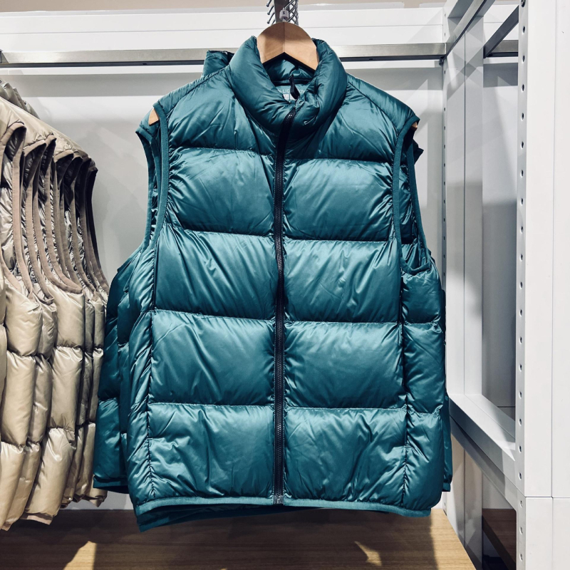 Unisex ziemas viegla pūka veste ar corduroy virsējā auduma, balta pīļu pūka 55–60% pilda, <100 g pildījums, kapuce, stāvošā apkakle, galvenais materiāls polipropilēns