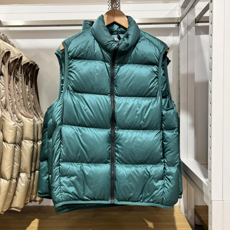 Unisex ziemas viegla pūka veste ar corduroy virsējā auduma, balta pīļu pūka 55–60% pilda, <100 g pildījums, kapuce, stāvošā apkakle, galvenais materiāls polipropilēns