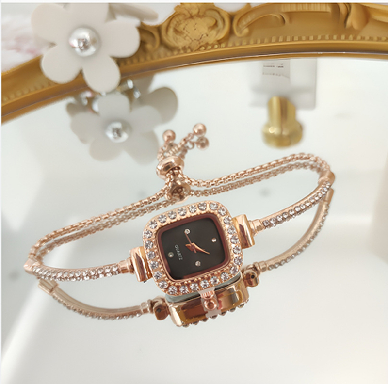 Ženski kvarcni sat s dekorativnim kamenčićima i svjetskim vremenom; metalno kućište i kaiš, okrugli brojčanik, leptir kopča