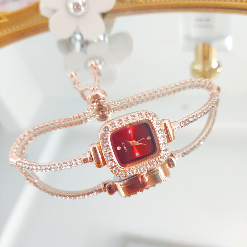 Ženski kvarcni sat s dekorativnim kamenčićima i svjetskim vremenom; metalno kućište i kaiš, okrugli brojčanik, leptir kopča