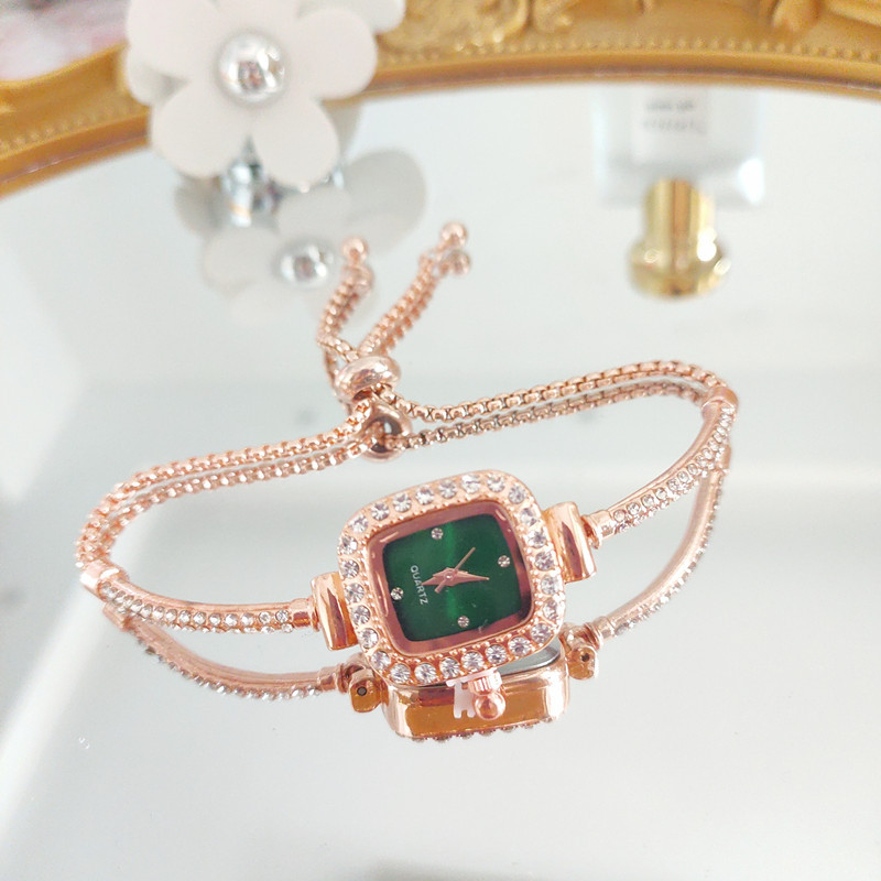 Ženski kvarcni sat s dekorativnim kamenčićima i svjetskim vremenom; metalno kućište i kaiš, okrugli brojčanik, leptir kopča