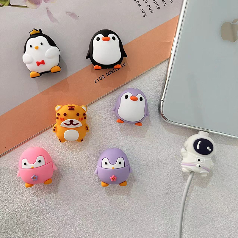 Apple duomenų kabelio vyniojimo įrenginys su karikatūriniu pingvino ir tigro dizainu; apsaugo kabelį nuo lūžimo; vyniojimo tipas: atviras; stilius: piešiniai; prekė Seven