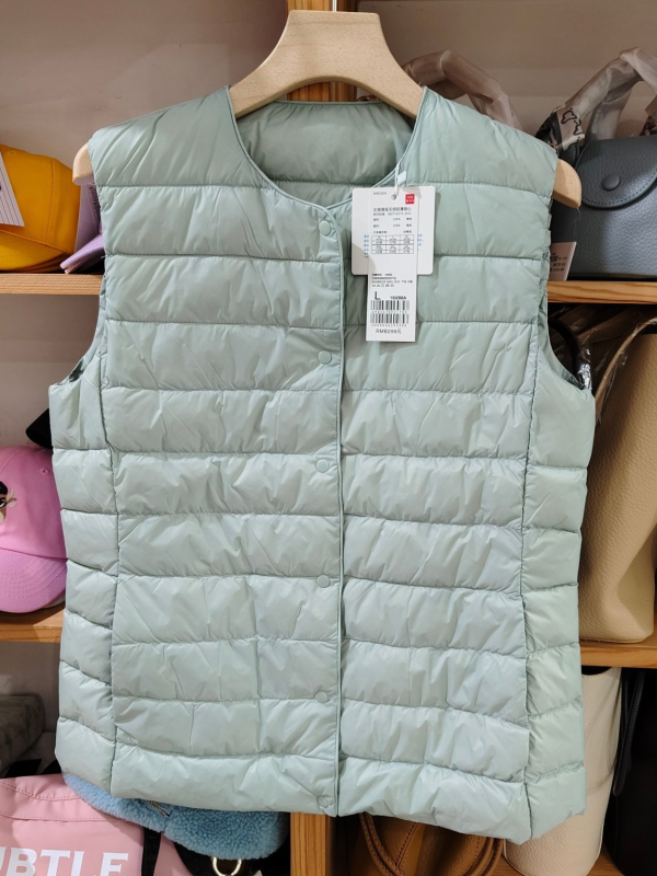 Sieviešu dūnu pildīta veste, vidēja biezuma, poliestera audums, kašmīrs 81–85%, garums 50–65 cm, apaļš kakla izgriezums, vienpogu aizdare, standarta griezums