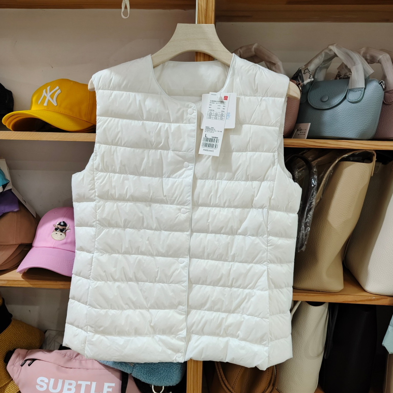 Sieviešu dūnu pildīta veste, vidēja biezuma, poliestera audums, kašmīrs 81–85%, garums 50–65 cm, apaļš kakla izgriezums, vienpogu aizdare, standarta griezums