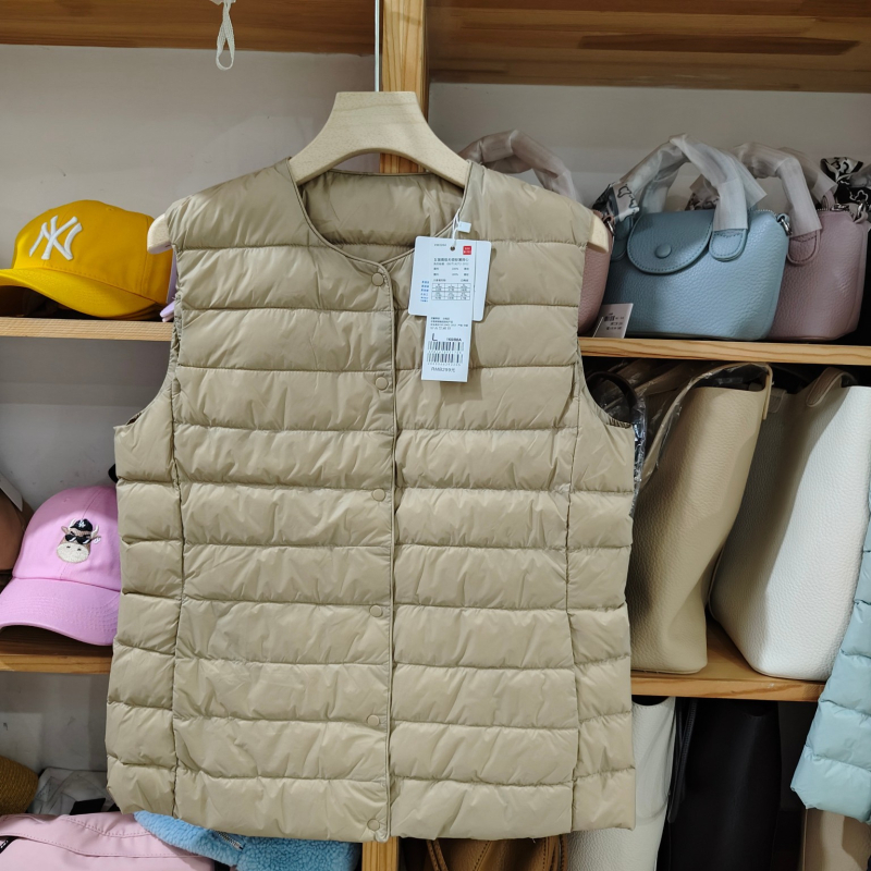 Sieviešu dūnu pildīta veste, vidēja biezuma, poliestera audums, kašmīrs 81–85%, garums 50–65 cm, apaļš kakla izgriezums, vienpogu aizdare, standarta griezums