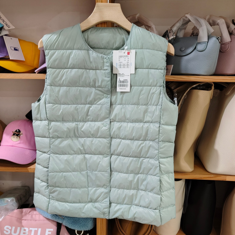 Sieviešu dūnu pildīta veste, vidēja biezuma, poliestera audums, kašmīrs 81–85%, garums 50–65 cm, apaļš kakla izgriezums, vienpogu aizdare, standarta griezums