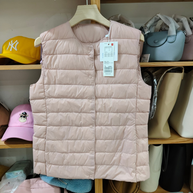 Sieviešu dūnu pildīta veste, vidēja biezuma, poliestera audums, kašmīrs 81–85%, garums 50–65 cm, apaļš kakla izgriezums, vienpogu aizdare, standarta griezums