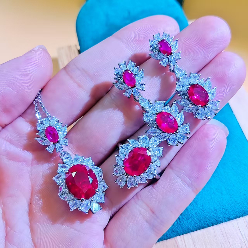 Virágos három darabos ékszerszett: gyűrű, nyaklánc, fülbevaló; alap bevonattal; betoldott szintetikus kövekkel; O alakú lánc; virág motívum