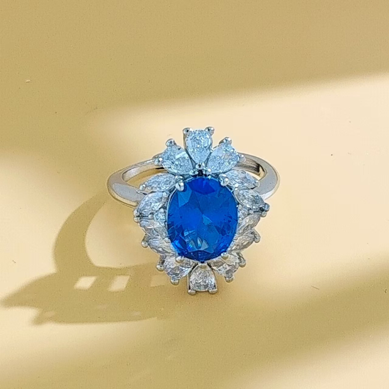 Virágos három darabos ékszerszett: gyűrű, nyaklánc, fülbevaló; alap bevonattal; betoldott szintetikus kövekkel; O alakú lánc; virág motívum