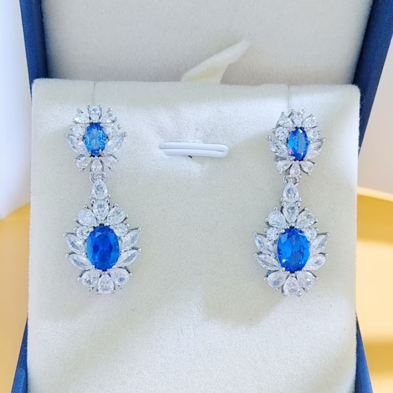 Virágos három darabos ékszerszett: gyűrű, nyaklánc, fülbevaló; alap bevonattal; betoldott szintetikus kövekkel; O alakú lánc; virág motívum