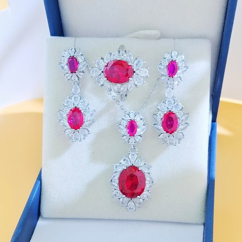 Virágos három darabos ékszerszett: gyűrű, nyaklánc, fülbevaló; alap bevonattal; betoldott szintetikus kövekkel; O alakú lánc; virág motívum