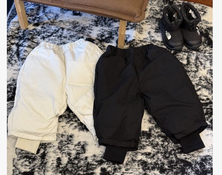 Meitenēm paredzēta pūkaina jaka ar kapuci – ar augstu apkakli, biezu pildījumu, 81–85% pīļu pūka, īss siluets