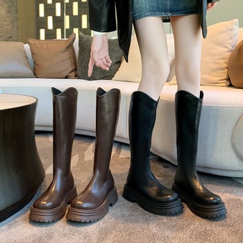 Cizme de damă tip cavaler, cu partea superioară din PU, talpă din cauciuc, gambă înaltă, toc gros 3-5 cm, închidere cu fermoar pe spate.