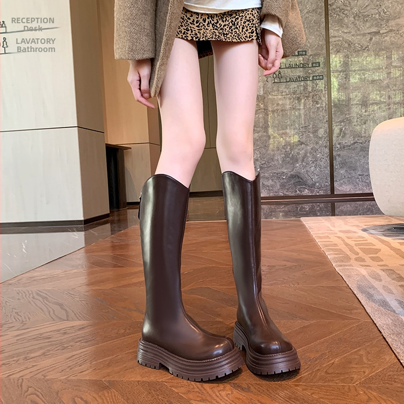 Cizme de damă tip cavaler, cu partea superioară din PU, talpă din cauciuc, gambă înaltă, toc gros 3-5 cm, închidere cu fermoar pe spate.