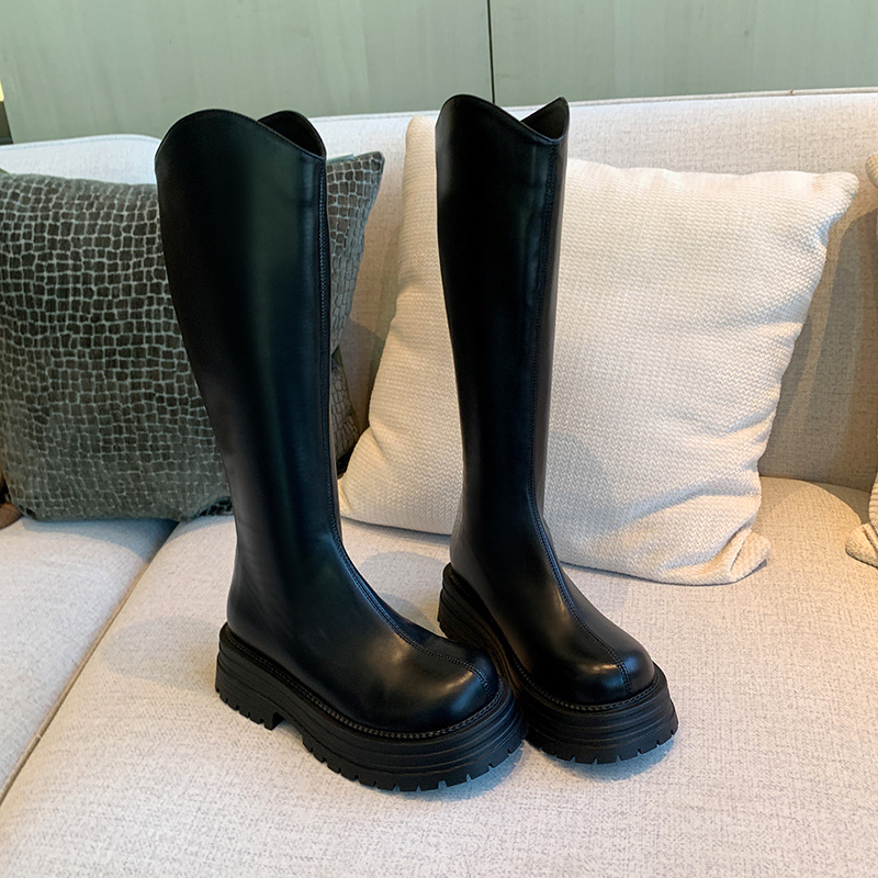 Cizme de damă tip cavaler, cu partea superioară din PU, talpă din cauciuc, gambă înaltă, toc gros 3-5 cm, închidere cu fermoar pe spate.