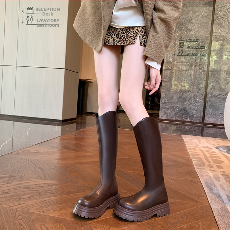 Cizme de damă tip cavaler, cu partea superioară din PU, talpă din cauciuc, gambă înaltă, toc gros 3-5 cm, închidere cu fermoar pe spate.
