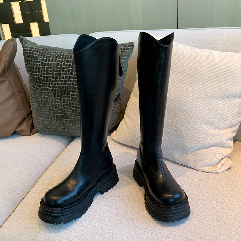 Cizme de damă tip cavaler, cu partea superioară din PU, talpă din cauciuc, gambă înaltă, toc gros 3-5 cm, închidere cu fermoar pe spate.
