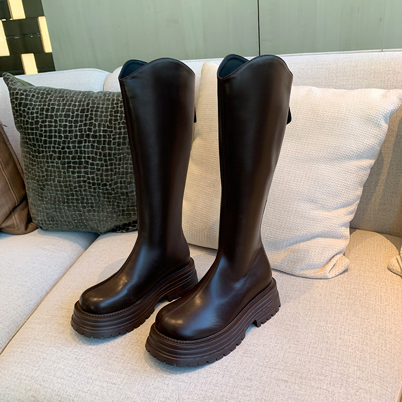 Cizme de damă tip cavaler, cu partea superioară din PU, talpă din cauciuc, gambă înaltă, toc gros 3-5 cm, închidere cu fermoar pe spate.