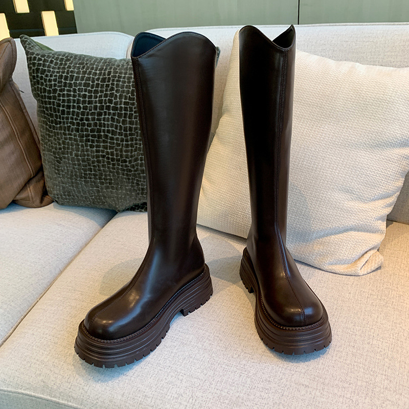 Cizme de damă tip cavaler, cu partea superioară din PU, talpă din cauciuc, gambă înaltă, toc gros 3-5 cm, închidere cu fermoar pe spate.