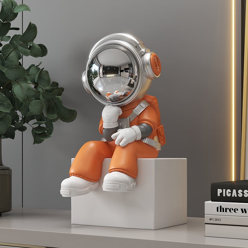 Sjedeći astronaut figura – smola, ručno obojena, moderni minimalistički stil