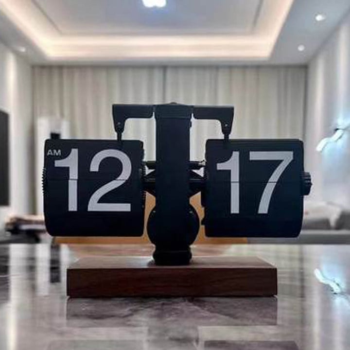 Pulkstenis ar bateriju, metāla korpusu un cipferiem, mūsdienīgs minimālisma stils.