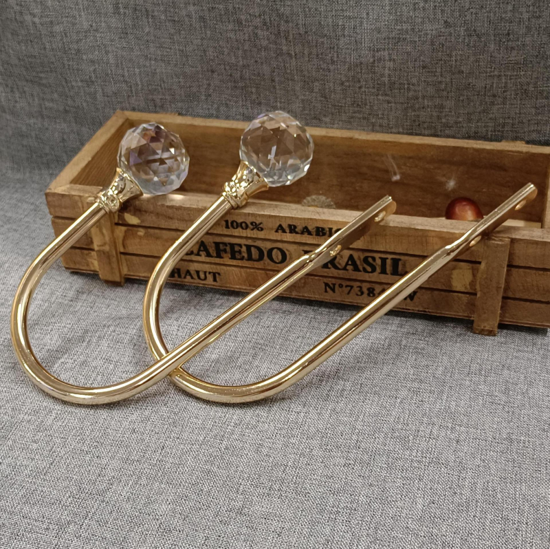Zidna kukica za zavjese — U-oblikovana kristalna kukica, model QX-109, materijal: metal + cinkov spoj + kristal; pribor: vijci + gumeni čep; za viseće zavjese