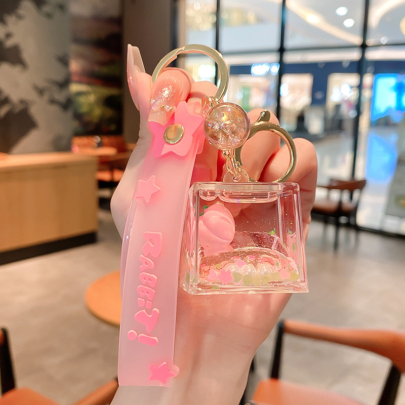 Képregényes kulcstartó, akril üvegben mozgó homokkal, gyerekek iskolatáskához