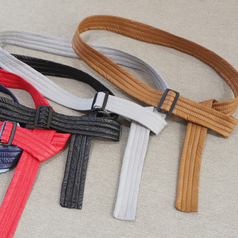 Sieviešu josta kapr­tam ar kokvilnas pildījumu, saitēm ar auklu, austā josta ar plastmasas sprādzi, mašīnas dizains, platums 2–4 cm